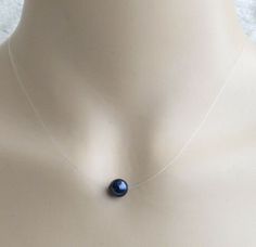 Beautiful elegant minimalistic necklace, strung on good quality illusion cord to give it a floating effect with a 8mm Swarovski night blue crystal pearl and choice of Gold plated, Silver Plated or Rose gold plated finish Different pearl colours are available (please look at photo 5) Comes with an organza gift bag All measurements mentioned is approximate The colour of the actual necklace might be slightly different to the photo due to the lighting   If you wish to customise the necklace design p Invisible Necklace, Minimalistic Necklace, Illusion Necklace, Necklace Design, Night Blue, Organza Gift Bags, Pearl Color, Minimalist Necklace, Crystal Pearls