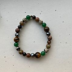 A handcrafted bracelet devoted to the earth element. Made using: Tourmaline- A grounding and protective stone, used to absorb negativity. Unakite- A highly nurturing stone used for healing and emotional centering. Dalmation Jasper- Carries playful energy, and helps connect you with your inner child. Green Aventurine- Brings in good luck, fortune, and prosperity. Tiger's Eye- A fiery stone that boosts confidence, promotes grounding and protection, and uplifts energy. Hematite- The magnetic qualities of this stone make it excellent for grounding and drawing abundance toward you. Leopard Jasper- Used for grounding, stability, connection to the earth, and an increase in confidence. I offer a variety of sizes to choose from, however, if you don't see your size listed, just message me and I'll m Dalmation Jasper, Earth Element, Earth Elements, Handcrafted Bracelets, Crystal Beads Bracelet, Confidence Boost, Prayer Beads, Green Aventurine, Inner Child