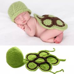 a newborn baby wearing a green hat and laying next to a crocheted leaf