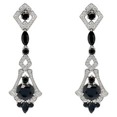 These exquisite earrings are crafted with meticulous attention to detail, inspired by the glamour and precision characteristic of the Art Deco era. At the heart of these earrings lie the captivating black spinels, each boasting a generous 4.70 carats. Surrounding the central spinels are an array of additional spinel gemstones, totaling an impressive 7.28 carats. Enhancing the elegance of these earrings are the shimmering F/G colored natural diamonds, totaling .79 carats. Set delicately in 18k white gold, these diamonds accentuate the overall brilliance of the design, creating a remarkable contrast against the darker gemstones. The intricate detailing and meticulous craftsmanship of these art deco-inspired earrings set them apart as a timeless piece of jewelry. These earrings also have a ma Black Diamond Earrings, Spinel Gemstone, Black Spinel, Matching Rings, Art Deco Era, Art Deco Inspired, Inspiration Art, Black Diamond, Timeless Pieces