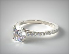 a white gold engagement ring with an oval cut diamond and pave set diamonds on the side