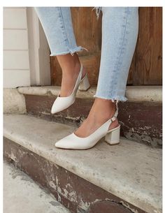 a woman in white shoes standing on steps