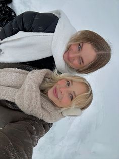 two women standing next to each other in the snow