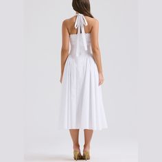 Embrace timeless beauty with this stunning A-line fit and flare midi dress. The halter neck provides a classic yet contemporary look, ideal for any fashionable wardrobe. Delicately crafted with pleated sides on the skirt, this dress combines elegance with a playful twist. Whether you’re attending a garden party, a cocktail event, or a dinner date, this dress is your go-to for effortless style and grace. Color: White, Pink, FloralSilhouette: Fit & FlareLength: MidiMaterial: PolyesterNeckline: Hal A-line Midi Dress With Pleated Bodice For Date Night, Chic A-line Tea Length Summer Dress, Chic A-line Maxi Dress With Tie Back, Chic A-line Tea Length Dress With Pleated Bodice, Classic A-line Midi Dress For Date Night, Fitted A-line Halter Sundress, Formal Sleeveless Midi Dress With Gathered Neckline, Spring A-line Midi Dress With Pleated Skirt, Chic Sleeveless Full Skirt Dress For Summer