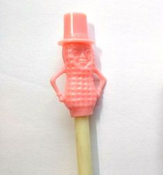 a pink toothbrush with a plastic figure on it