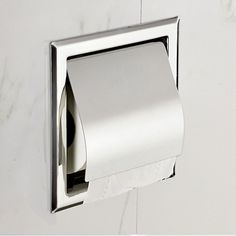 a toilet paper dispenser mounted on the wall next to a roll of toilet paper