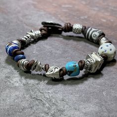 "Reflecting on my travels and experiences, and the people I have met and the places I have lived and seen made me want to create something that represented a mix of those.  So I expanded a bit on my Chunky Monkey design and added some antique genuine trade beads, a single genuine turquoise nugget, and an array of mixed shapes of handmade pewter in fun organic shapes and sizes.  All on dark antique brown leather finished with an easy pewter button.   Fits 6.5\" - 7\" wrist.  Need a different size?  Message me and I'll be happy to help. *Due to the nature of the handmade trade beads your bracelet may not look exactly like the one shown, but your bracelet will contain the same mix of beads as shown.  If you would like to see your bracelet prior to shipping please leave me a note in the notes Nickel-free Bohemian Beaded Bracelets For Healing, Bohemian Silver Beads Bracelets For Healing, Bohemian Silver Beads Bracelet For Healing, Artisan Beaded Bracelets With Nickel-free Round Beads, Adjustable Nickel Free Artisan Bracelets, Handmade Spiritual Leather Bracelet With Round Beads, Unique Nickel-free Beaded Bracelets For Festivals, Handmade Spiritual Leather Bracelet, Handmade Spiritual Leather Bracelet For Everyday