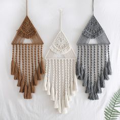 three macrame wall hangings with tassels and fringes on them