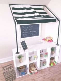 a black and white striped awning over a shelf filled with food on top of a hard wood floor