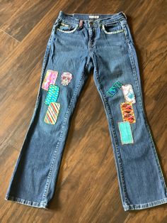 This is a vintage Levi's blue jeans size 4.  Hand embroidered with vintage fabric, patches and embroidery. Denim Blue Jeans With Patches For Spring, Spring Denim Blue Jeans With Patches, Medium Wash Jeans With Patches For Spring, Spring Jeans With Patches In Medium Wash, Spring Medium Wash Jeans With Patches, Straight Leg Denim Jeans With Collage Stitching, Mid-rise Patchwork Cotton Jeans, Spring Straight Leg Jeans With Patches, Casual Denim Bottoms With Embroidered Patch