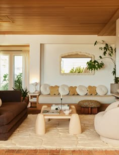 a living room filled with furniture and plants