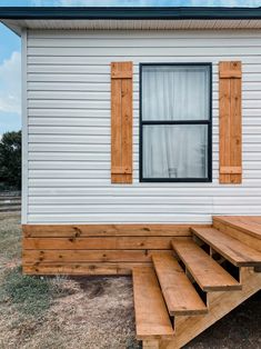 a small white house with wooden steps leading up to it