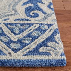 a blue and white area rug on a wooden floor with hard wood flooring in the background