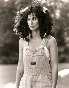 an old black and white photo of a woman in overalls