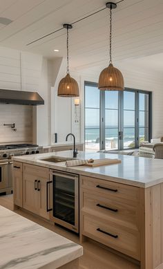 a large kitchen with an island and two pendant lights