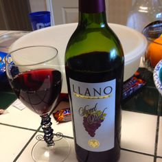 a bottle of wine sitting next to a glass filled with red wine