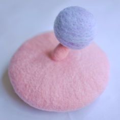 a wool ball on top of a pink and purple object