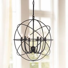 a black chandelier hanging from a ceiling in a room with white walls and windows