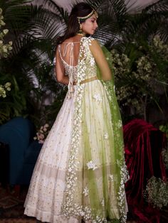 This ivory chikankari lehenga is detailed with zardosi, pearls and sequins on a georgette base. It is paired with a tussar silk blouse that has a scalloped neckline.  The outfit is completed with a  contrast green net dupatta. Cream Anarkali Set With Cutdana For Reception, Off White Chikankari Embroidery Sets For Reception, White Cutdana Lehenga For Reception, Off White Wedding Choli With Cutdana, Off White Cutdana Lehenga For Eid, Off White Cutdana Choli For Wedding, Off-white Cutdana Lehenga For Eid, Wedding Lehenga In Off White With Cutdana, White Raw Silk Dress With Cutdana