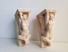 two carved ivory bookends with female figures on the front and one holding a cup