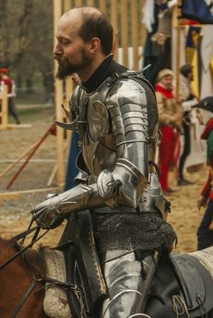 a man in armor riding on the back of a horse