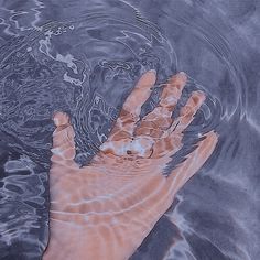 a person's hand is submerged in water