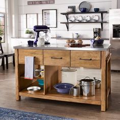 a kitchen island with pots and pans on it in the middle of a room