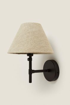 a wall light with a lamp shade on it's side and a white background