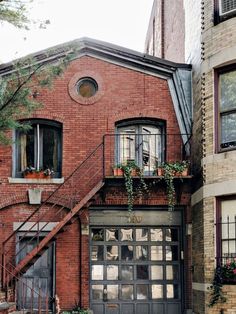 an old brick building with plants growing out of the windows and on the second story