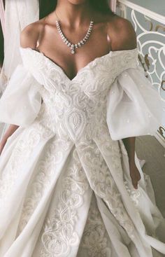 a woman in a white wedding dress is posing for the camera