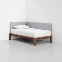 a bed that is sitting in the middle of a room next to a white wall