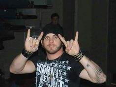 a man with two fingers up in front of his face and one hand holding the peace sign