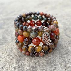 Earth tones of green, brown, red and orange define this 5 wrap boho bracelet.Genuine semi-precious stones featuring Tiger's Eye, Jasper, and Crackle Agate make up this done-for-you stack. 4mm round jasper 8mm Tiger's Eye 10mm faceted Crackle Agate one size fits most - best for small to medium wrists Handmade in Lincoln, Nebraska Multicolor Wrap Bracelet With Round Beads And Natural Stones, Bohemian Beaded Bracelets With Gemstone Beads, Spiritual Brown Stackable Beaded Bracelets, Bohemian Beaded Bracelets With Natural Stones For Layering, Spiritual Natural Stone Bracelets For Layering, Spiritual Natural Stones Bracelets, Bohemian Natural Stone Beaded Bracelets, Earthy Brown Wrap Bracelet With Round Beads, Earthy Hand Wrapped Wrap Bracelet