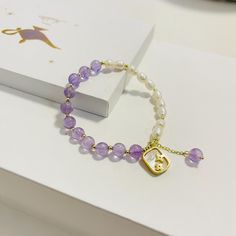 A beautiful bracelet made for everyone! A amethyst, pearl bracelet with a gold square charm. Elegant Gold Charm Bracelet With Natural Stones, Elegant Purple Bracelets As Gift, Elegant Purple Bracelets For Gifts, Elegant Purple Beaded Bracelets As Gift, Elegant Purple Beaded Bracelets For Gift, Elegant Purple Beaded Bracelet For Gift, Elegant Purple Beaded Bracelet Gift, Elegant Lavender Beaded Bracelets, Elegant Charm Bracelet With Natural Stones