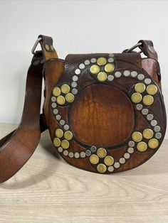 Really unique Vintage Hand Tooled hand Stitched Leather Shoulder Bag/Purse With Metal Rivets Deco Really Thick Leather boho, weight over 1lb13oz. The bag is 9" wide 8" height and 4'" deep. The strap is not adjustable. From the bottom of the bag to the far end of the strap is a little bit over 25”. There is one metal rivet missing, you can see it from the last photo, which is not effect the use of the bag. Please check all the photos for details as they are part of the description. Shipped with U Vintage Satchel With Adjustable Strap For Festival, Leather Bag With Removable Pouch For Festivals, Brown Satchel Saddle Bag For Festivals, Vintage Brown Bag As Fashion Accessory, Vintage Crossbody Shoulder Bag As Fashion Accessory, Vintage Brown Bags As Fashion Accessory, Bohemian Soft Leather Satchel Bag, Artisan Leather Shoulder Bag For Festival, Leather Bags With Adjustable Strap For Festivals