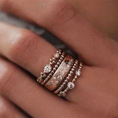 a woman's hand with three rings on her finger and one ring in the middle