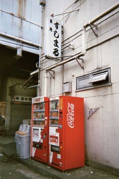 two vending machines sitting next to each other on the side of a building