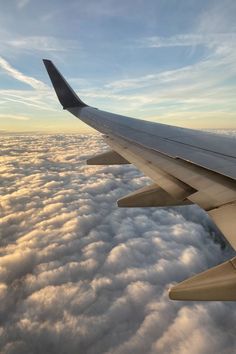 the wing of an airplane flying above clouds