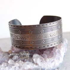 Elaborately engraved silver plated cuff bracelet is in a Victorian style with a central band of acanthus leaves flanked by bands of tiny ridges, flowers, milgrain engraving and a dentille border. The engraving is definitely a cut above what is normally seen on this type of bracelet. It has a lovely, lightly tarnished patina. Size: About 7 interior circumference (including the gap) and 1 inch wide. Age: Unknown, but my hunch is about 1970s, when Victorian style was very popular. Materials: Silver plated base metal. Not attracted to a magnet. Marks: Unmarked Condition: Excellent pre-owned condition. Light tarnish. Plating is in good condition, no bare spots. SHIPPING INFO: This item ships for free to the United States. I use Calculated Shipping for international orders. If I can ship for les Engraved Cuff, Acanthus Leaves, Victorian Revival, Sterling Silver Brooch, Acanthus Leaf, Hinged Bracelet, Sterling Silver Cuff Bracelet, Silver Engraving, Silver Brooch