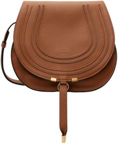 Grained calfskin saddle bag in tan. Burnished edges throughout. · Adjustable pin-buckle shoulder strap · Logo embossed at face · Concealed patch pocket at face · Foldover flap with tab-slot closure · Card slot at interior · Linen twill lining · H10 x W11.5 x D4.5 in Supplier color: Tan Chloe Marcie, Saddle Bag, Saddle Bags, Patch Pocket, Saddle, Apparel Accessories, Calf Skin, Chloe, Shoulder Strap