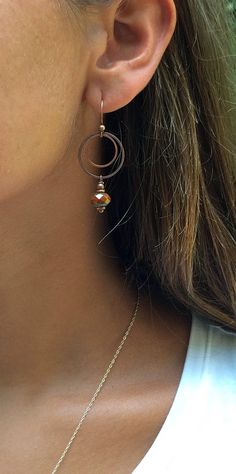 "Burnt orange dangle earrings with antiqued copper. Small, light-weight copper and Czech glass earrings that are perfect for your fall jewelry collection! The Czech glass is a beautiful, rustic, faceted burnt orange focal piece that dangle from two small antiqued copper rings. Product overview: - Made with Czech glass and antiqued copper - Total hanging length is 2\", the largest ring is the diameter of a penny - Small, versatile and light-weight - Hypoallergenic ear wires (lead and nickel free) Nickel-free Rust Drop Earrings, Rust Copper Dangle Earrings, Rust Color Dangle Earrings With Ear Wire, Rust Dangle Earrings With Ear Wire, Rust Copper Dangle Jewelry, Rust Colored Copper Dangle Jewelry, Rust-colored Copper Dangle Jewelry, Orange Copper Dangle Earrings, Bronze Copper Hoop Earrings