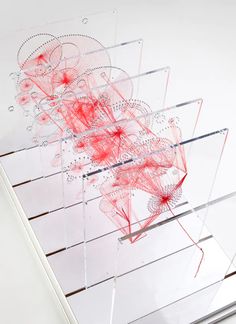 an abstract piece of art is displayed on a white surface with red lines and dots