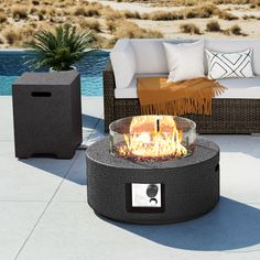 a fire pit sitting on top of a patio next to a couch