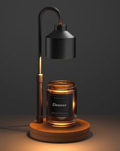 an illuminated candle on a wooden stand next to a black lamp with a gold base