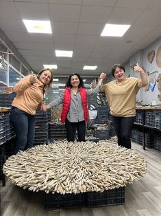 three women standing in front of a table made out of bananas