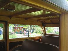 the interior of an old fashioned bus with people walking around in the back and inside