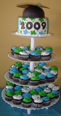 three tiered cake with cupcakes on top