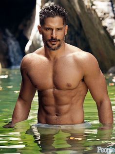 a shirtless man standing in the water with his hands on his hips and looking at the camera