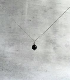 "Shungite pendant necklace for women - executes an effortlessly elegant hint of sparkle to any outfit.  Explore ways to layer this piece or wear it on its own for a minimal look. Dainty, minimal, stylish necklace. Great gift idea for women (wife, girlfriend, mom, sister...). Necklace length: 36 cm (14\") + 5cm (2\") chain extension.  Please email me for a longer or shorter size of the necklace. Shungite bead - 10 mm. Shungite: * protects one against the draining/stealing of vibrational energy fr Minimalist Crystal Choker Necklaces As Gifts, Minimalist Crystal Choker Necklace As Gift, Minimalist Pendant Charm Necklaces For Meditation, Minimalist Black Gemstone Beads Necklace, Black Minimalist Necklace With Gemstone Beads, Minimalist Silver Necklace With Gemstone Beads, Everyday Black Round Pendant Necklace, Minimalist Beaded Necklace With Pearl Pendant For Gift, Black Round Pendant Necklace For Everyday