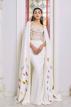 Description Off-White Column, Long dress Cape shape, Long Sleeves Open neckline Crepe, Crystal beading Dry Clean Made in Lebanon Design 1 Lebanon Design, White Fitted Dress, Dress Cape, Long Cape, Column Gown, Beaded Bodice, Cape Sleeves, Color Beads, Cape Dress